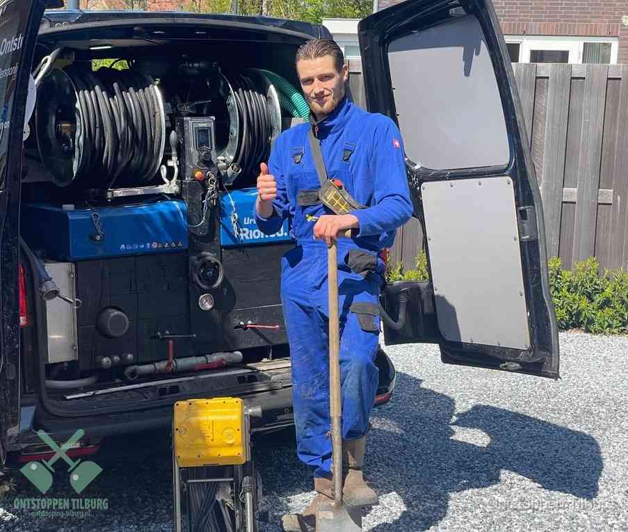 Een tevreden monteur met opgestoken duim naast de bestelbus, slim ingrijpen bespaart kosten bij een verstopte afvoer in Tilburg
