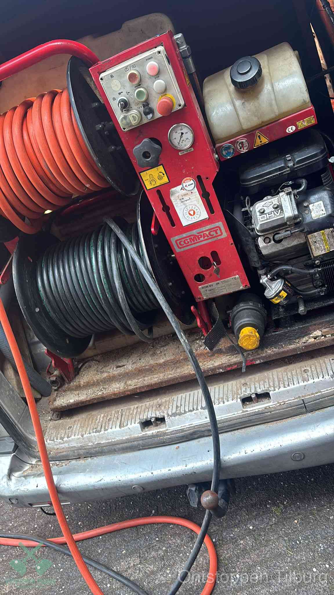 Een rood hogedruk-rioolreinigingstoestel in de laadbak van de bedrijfsbus, apparatuur voor een hardnekkige afvoerverstopping in Tilburg