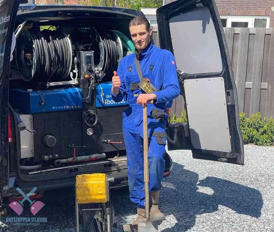 Een monteur bij de werkbus met grote hogedruk-slanghaspels, apparatuur voor hardnekkige afvoerverstoppingen in Tilburg