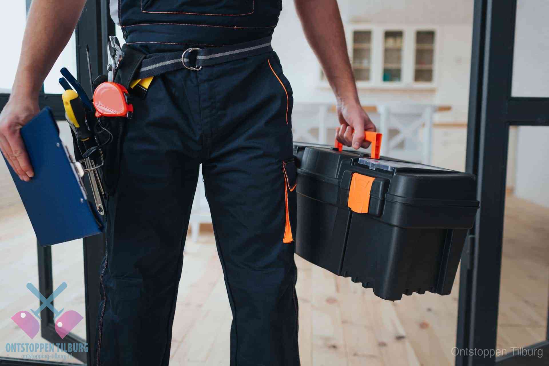 Een monteur met gereedschapsriem en klembord in een keuken, klaar om een transparante prijs voor het gootsteen ontstoppen in Tilburg te geven