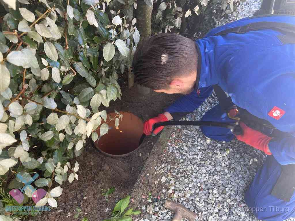 Monteur reinigt een rioolput met een slang, periodieke rioolreiniging in Tilburg
