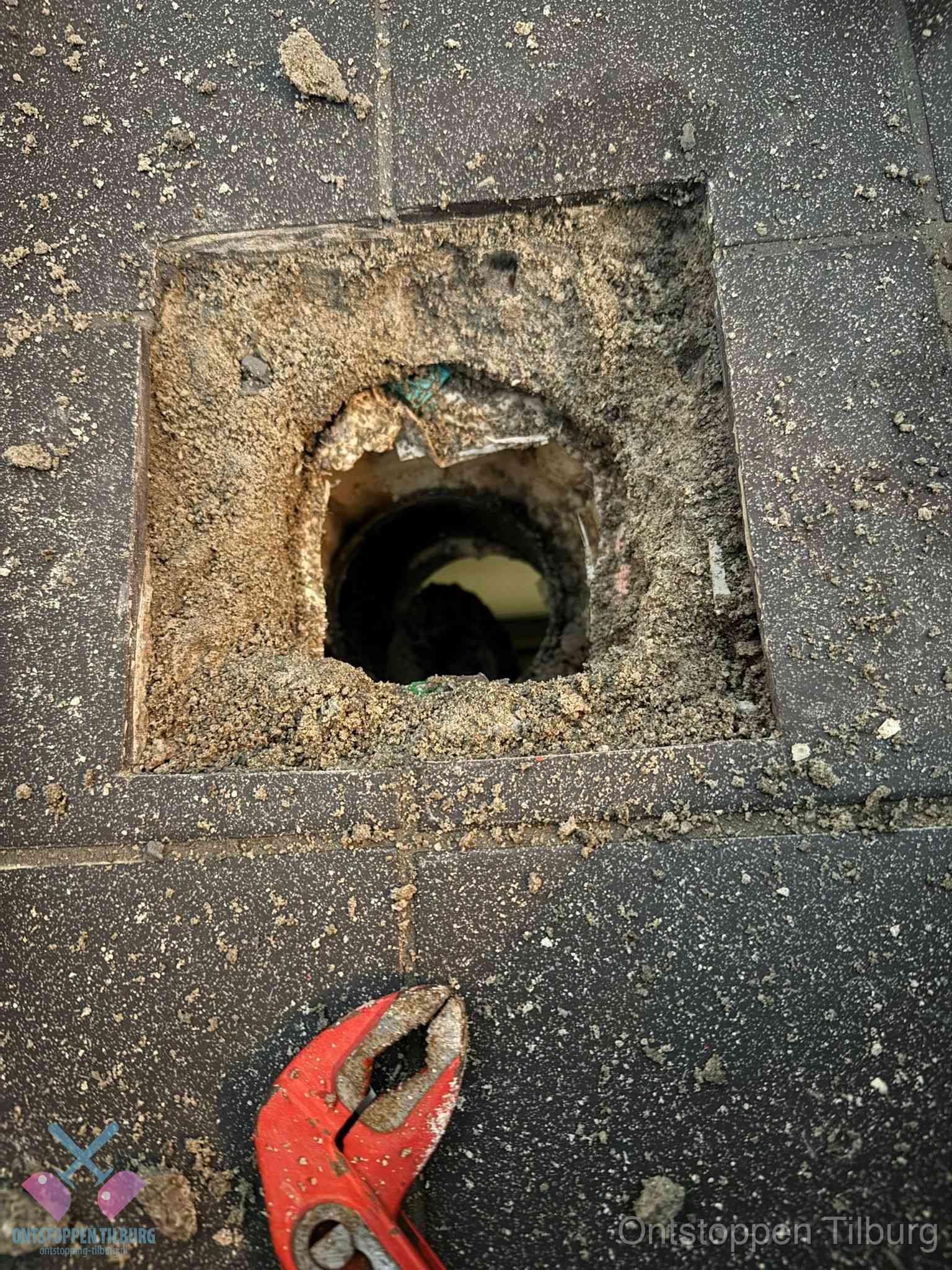 Geopend rioolputje op de erfgrens dat laat zien wie eigenaar is van de riolering in Tilburg