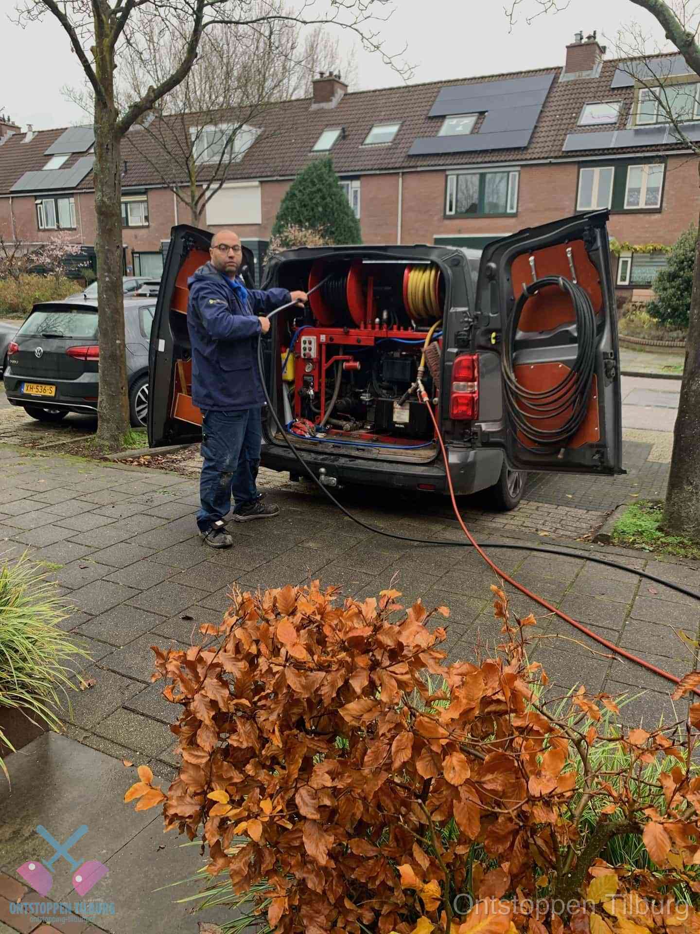 Monteur met rioolreinigingsbus levert rioolservice in de wijk in Tilburg