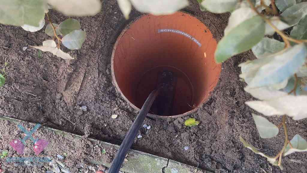 Open inspectieput in de tuin waar een veer rioolvliegjes en stankoverlast aanpakt in Tilburg
