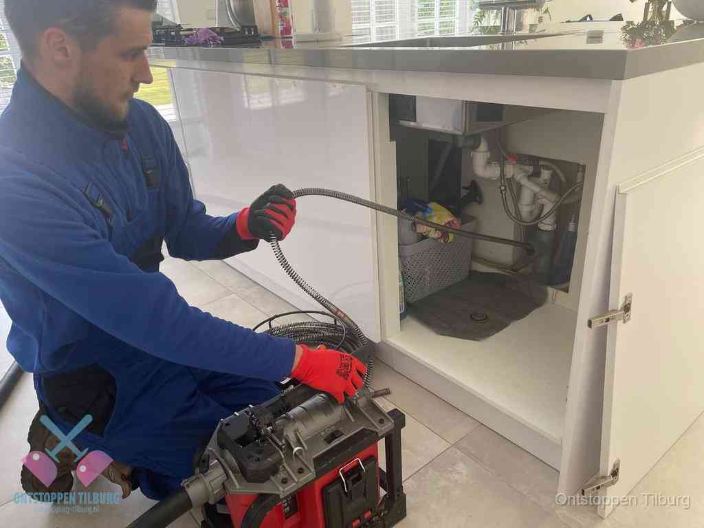 Een monteur reinigt de keukenafvoer grondig met een veermachine om terugkerende gootsteenverstoppingen te voorkomen in Tilburg